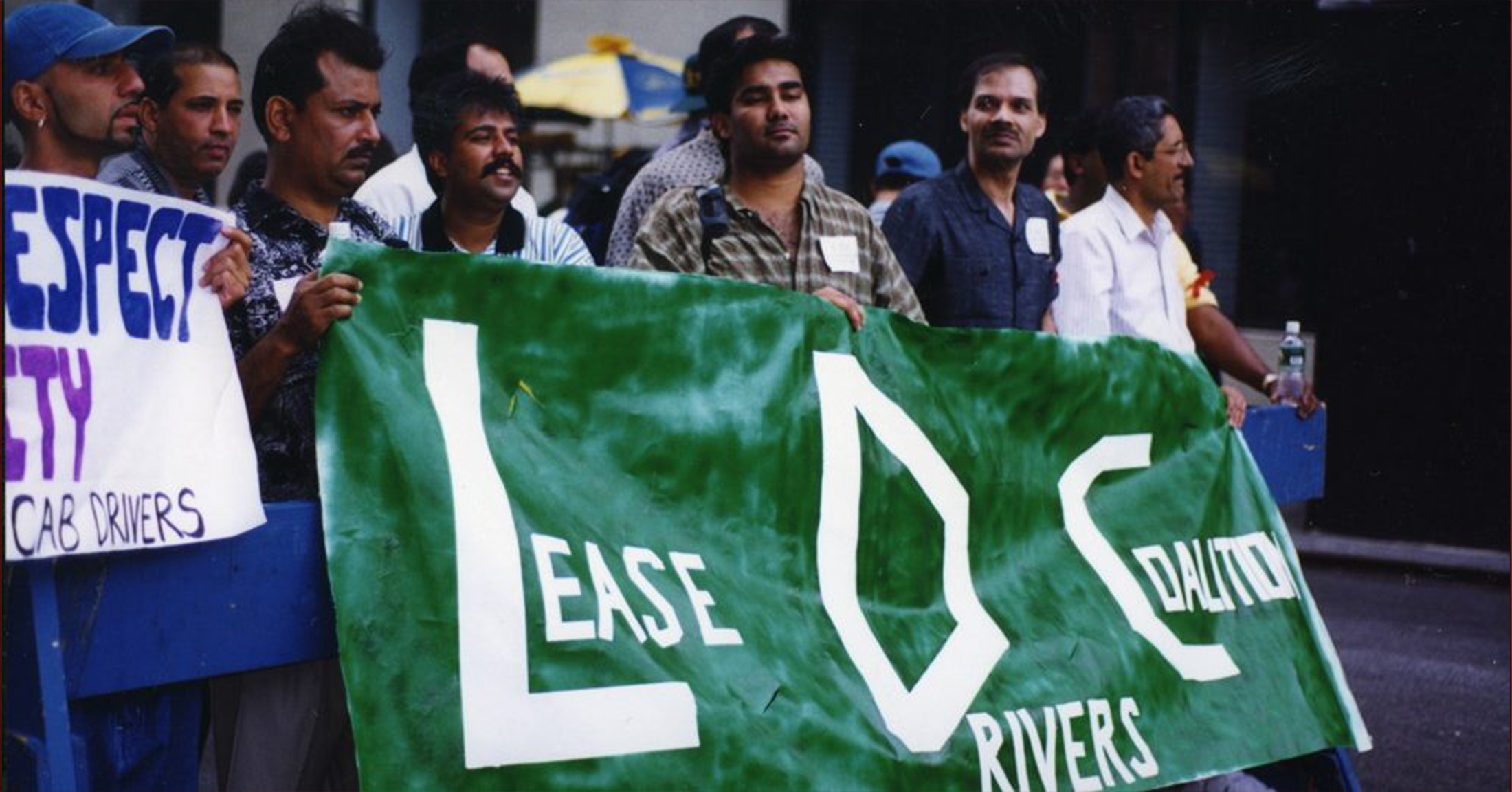 NYTWA members marching with a a green banner that says, "Lease Drivers Coalition."