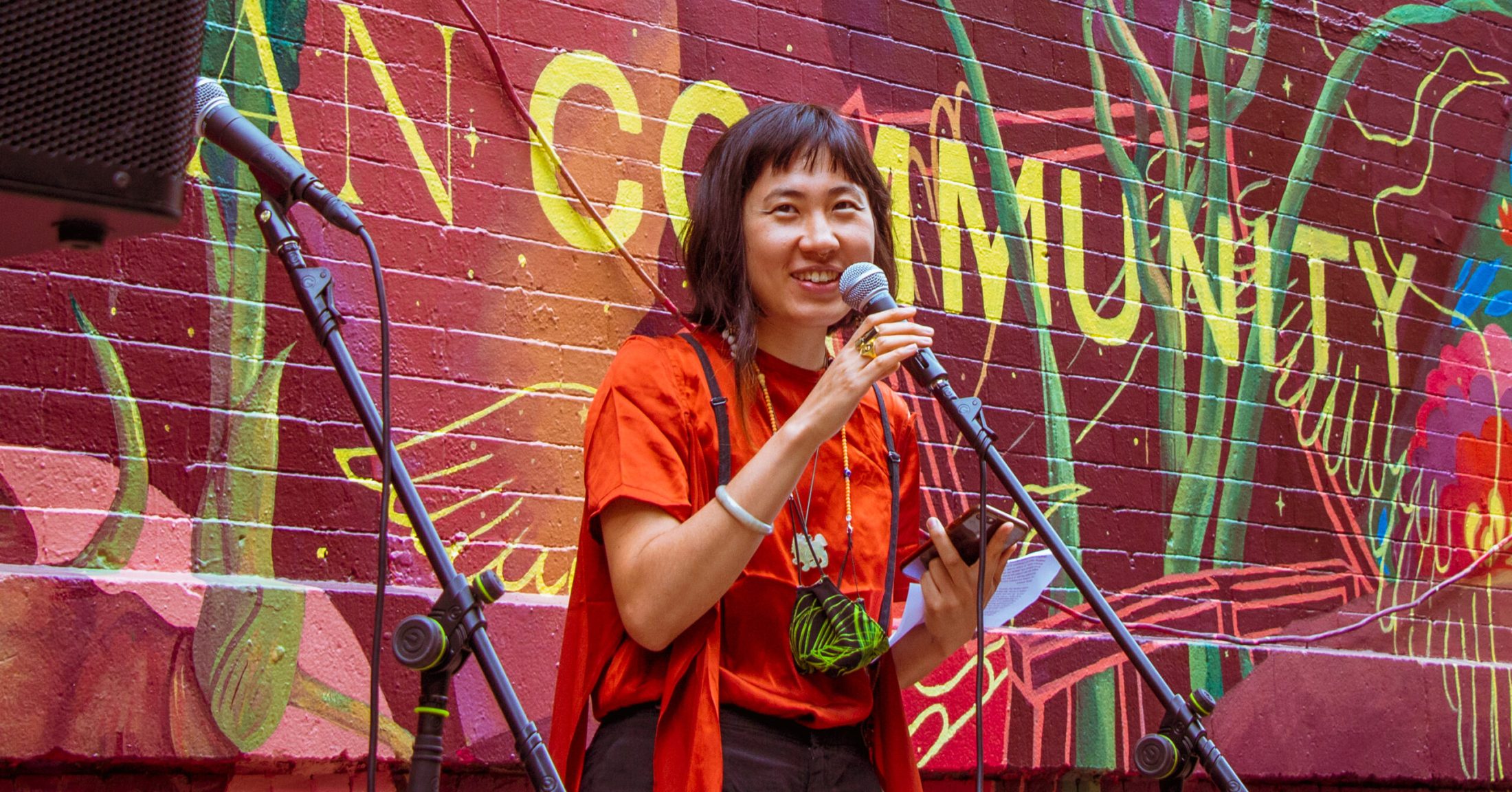 Jess X. Snow stands in front of a microphone