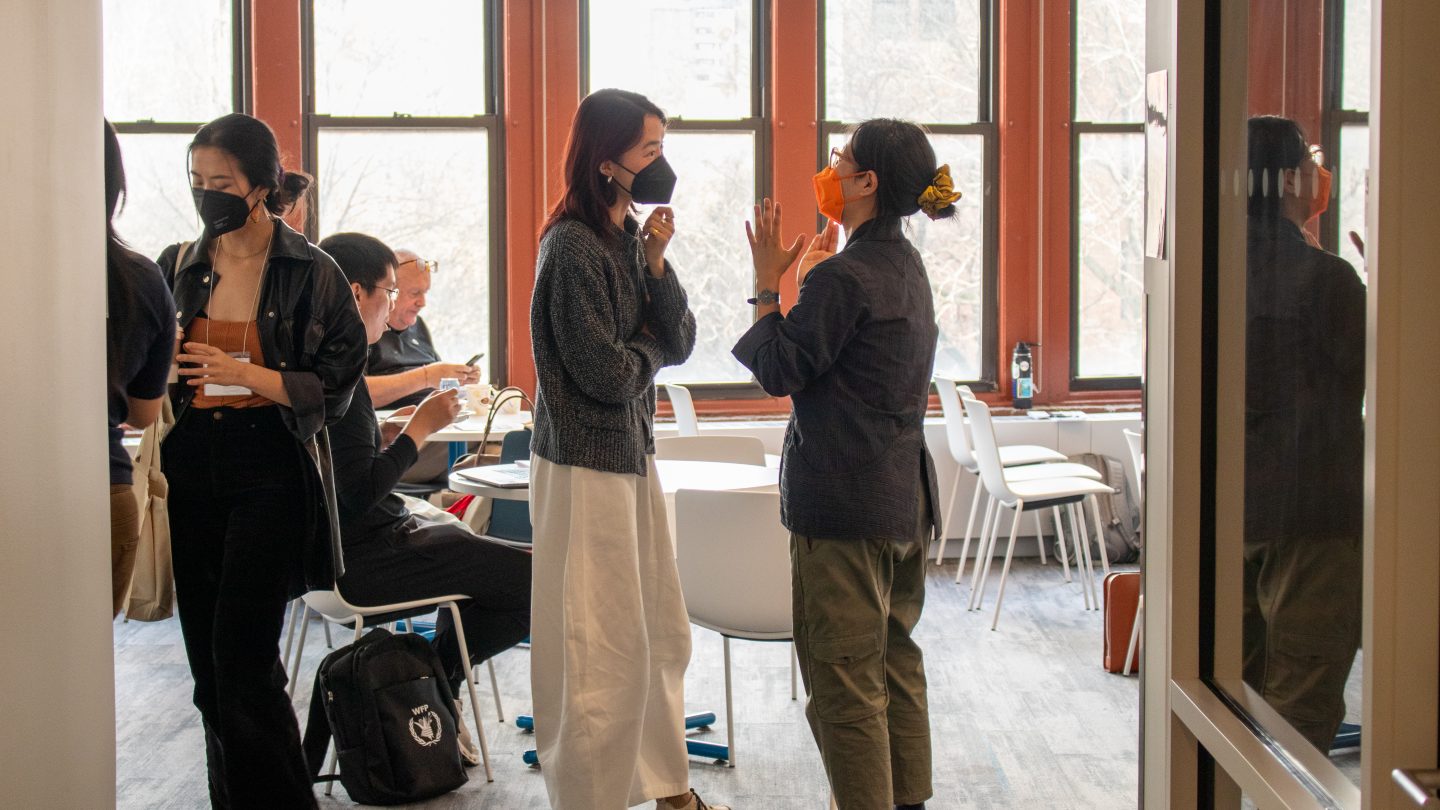 A photograph of graduate students socializing and talking at an A/P/A Graduate Student Working Group social.