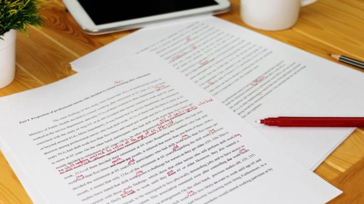 A image of typed dissertation pages marked up in red inl.