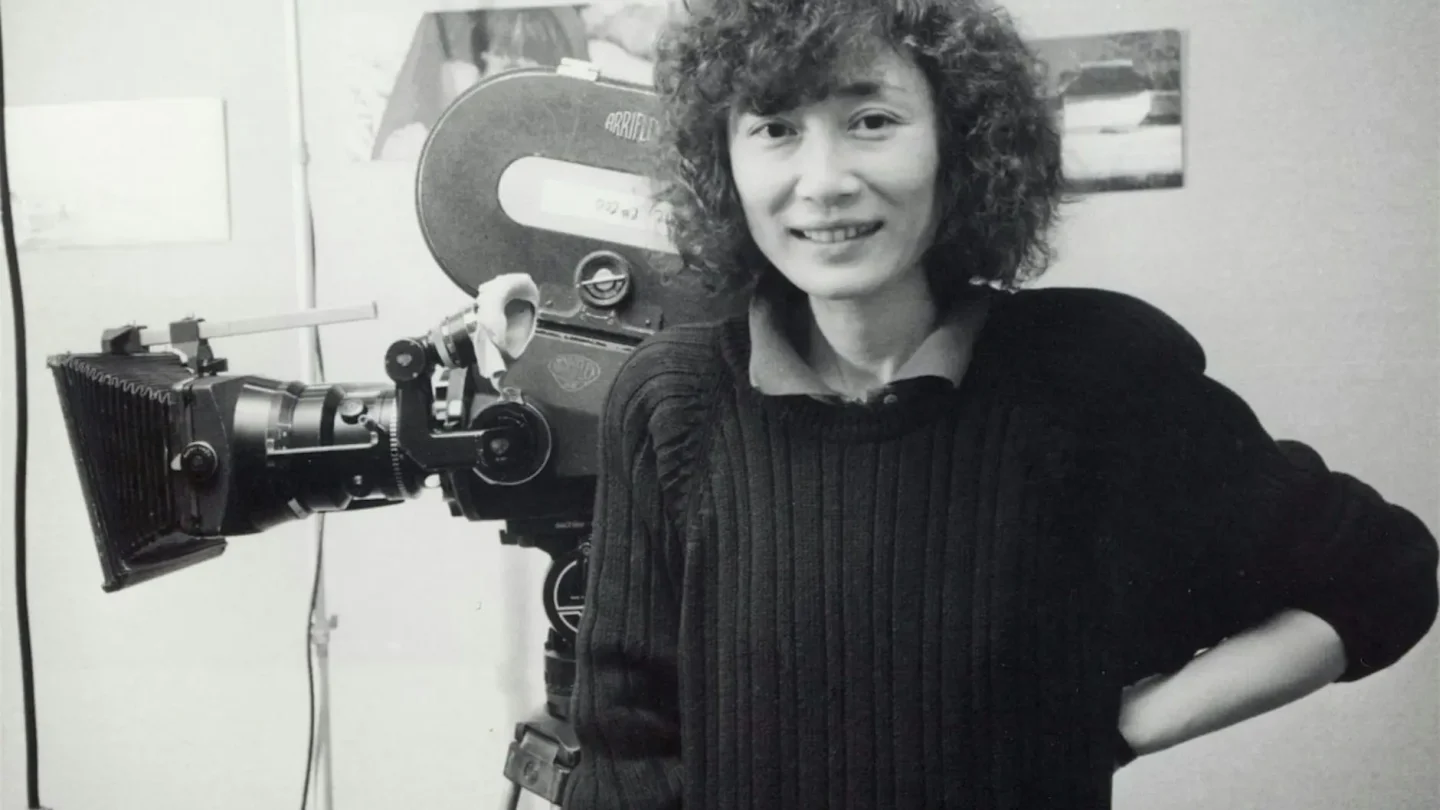 A black and white photograph of Christine Choy. She stands in front of the camera.