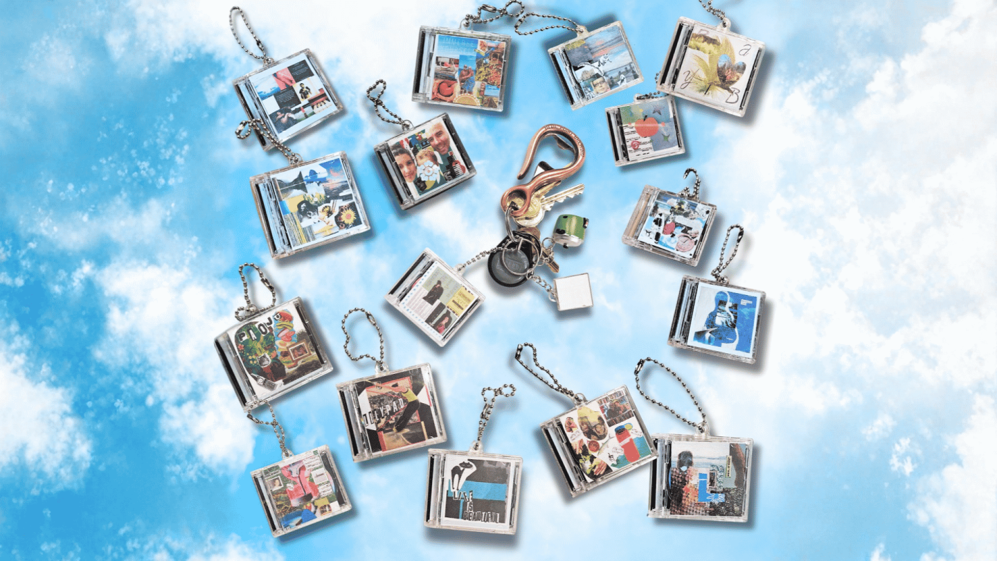 A collage image of mini CD keychains each with a unique image on the cover. They are arranged against a cloud background.