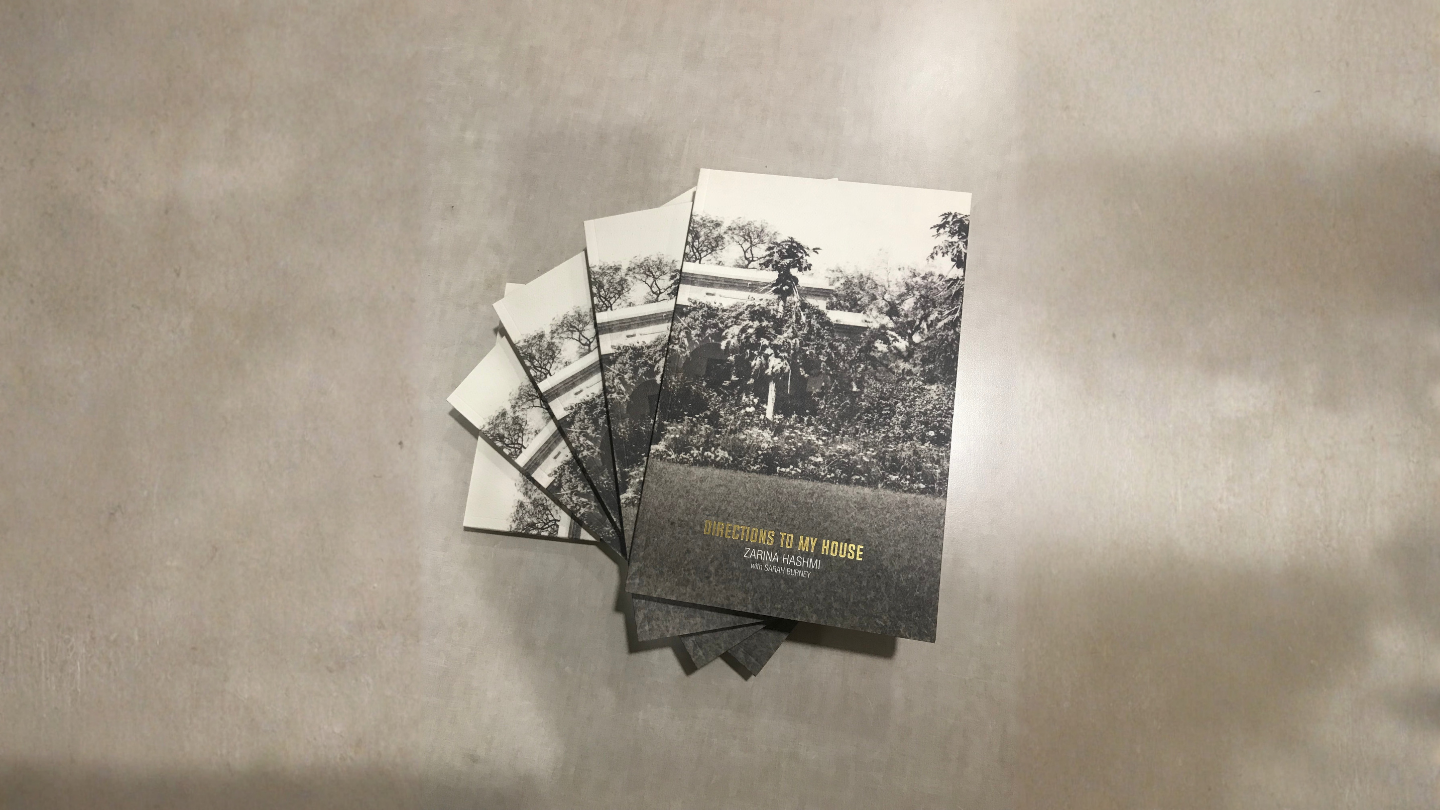 A photograph of 5 copies of the book "Directions to My House" by Zarina Hashmi with Sarah Burney.