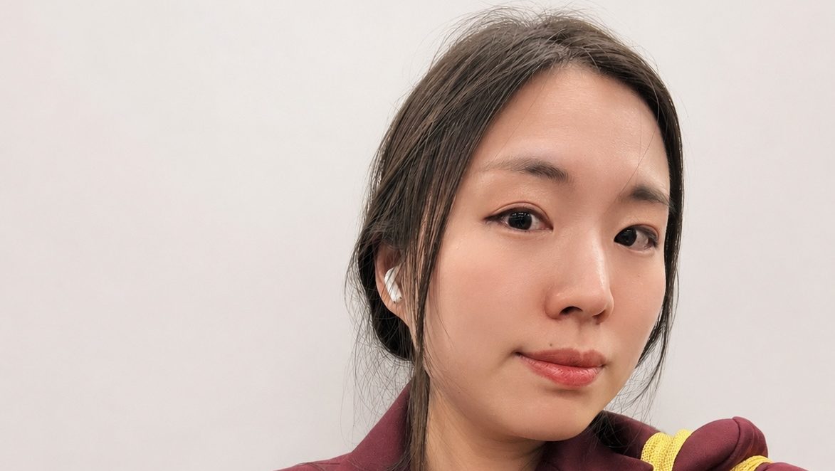 Photograph of Bonnie Yonbom Chung looking at the camera. She wears a maroon coat and yellow bag.